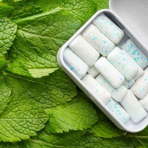 An open box of chewing gum on mint leaves